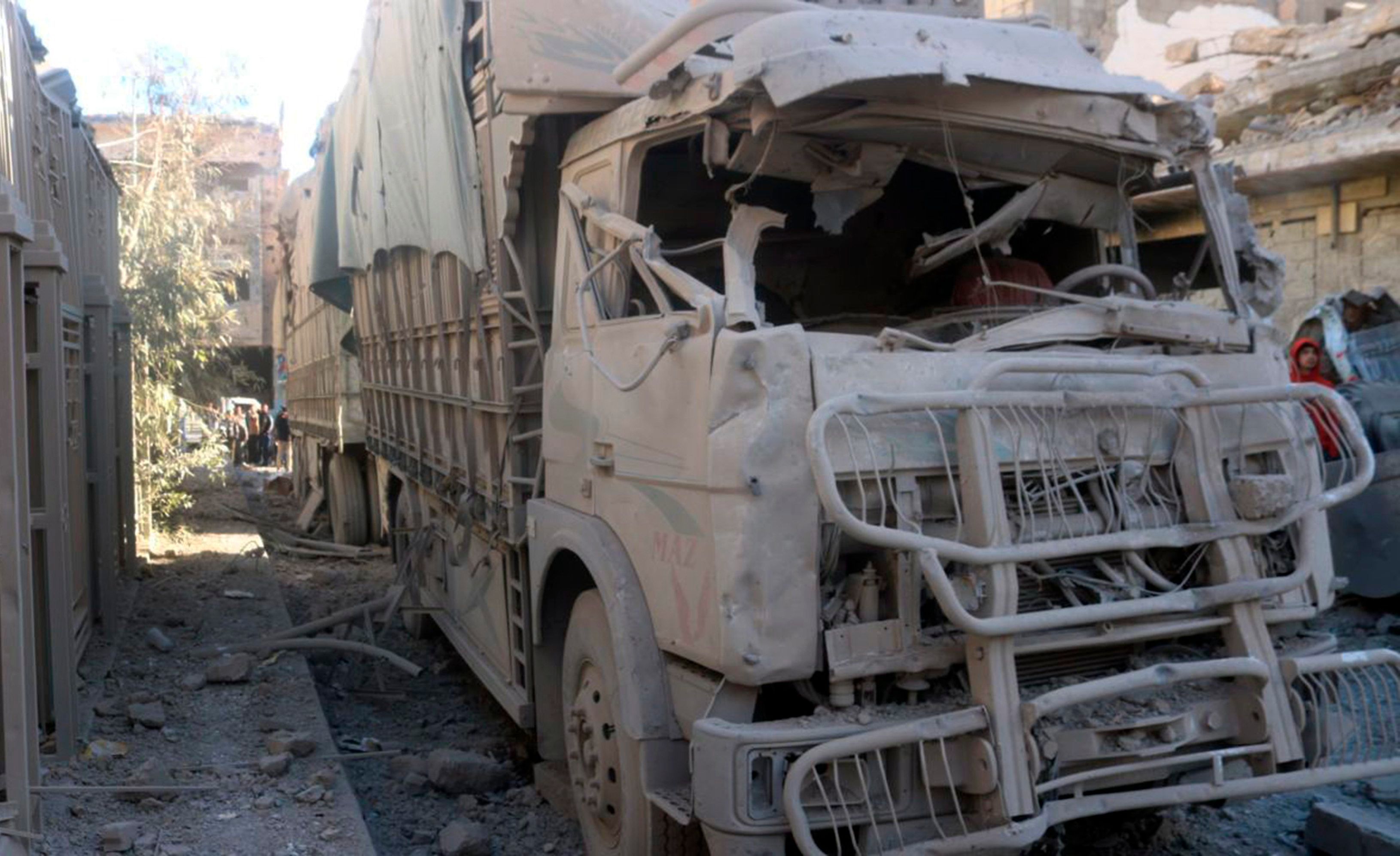 Ein LKW wurde nach der Explosion eines Gebäudes zerstört und steht rußbedeckt auf einer Straße.