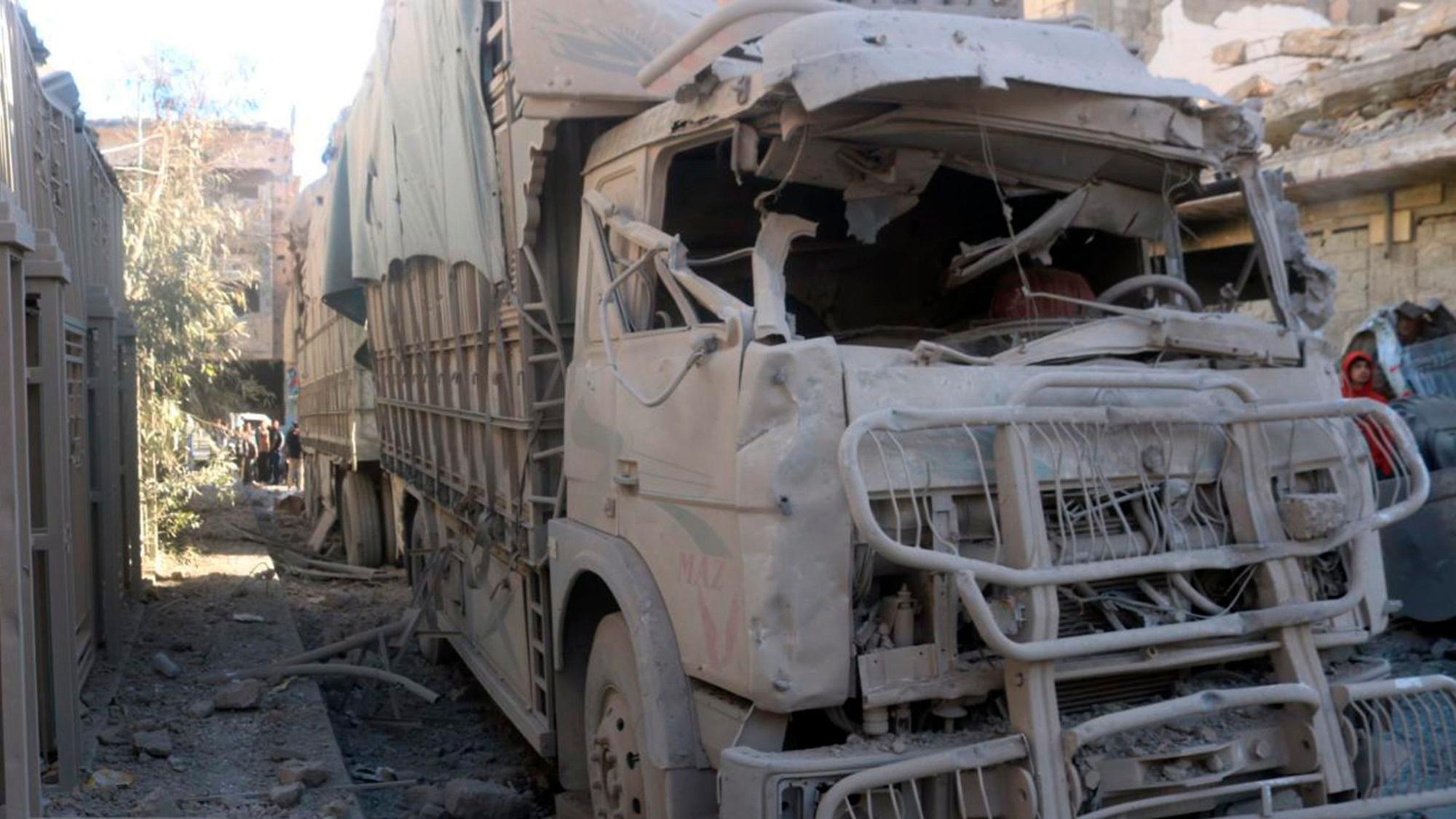 Ein LKW wurde nach der Explosion eines Gebäudes zerstört und steht rußbedeckt auf einer Straße.