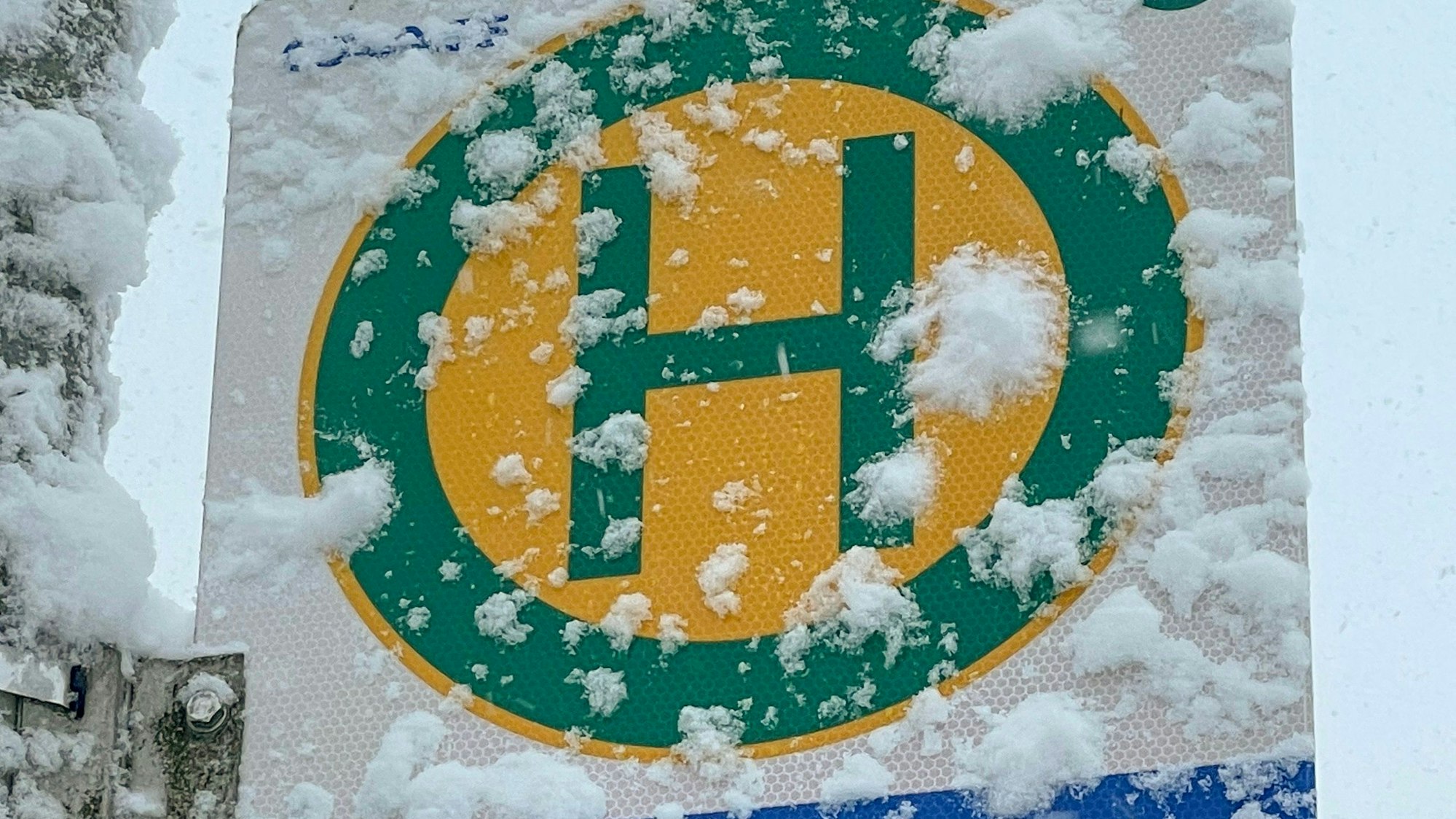 Ein verschneites Schild, das auf eine Haltestelle hinweist