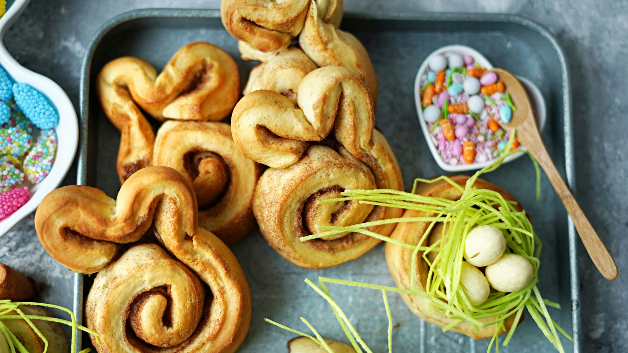 Ein Teil der Zimtschnecken werden als Nester dekoriert, der andere Teil bekommt Hasenohren verpasst.