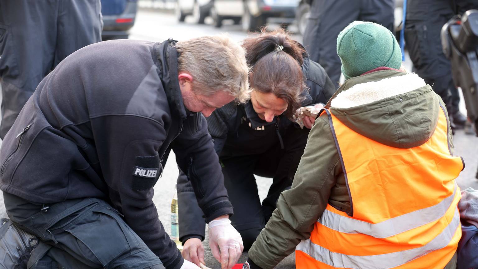 Klima-Aktivisten der „Letzten Generation“ werden durch Einsatzkräfte der Polizei von der Straße gelöst. (Archivfoto)