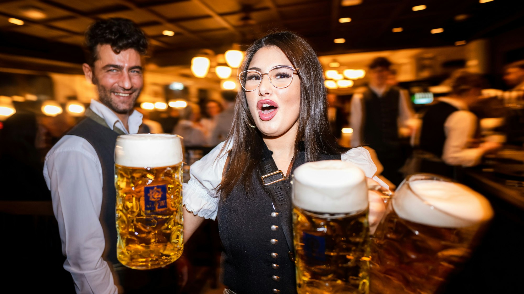 Eine Kellnerin trägt im Augustiner am Heumarkt drei große Bierkrüge durch das Brauhaus.