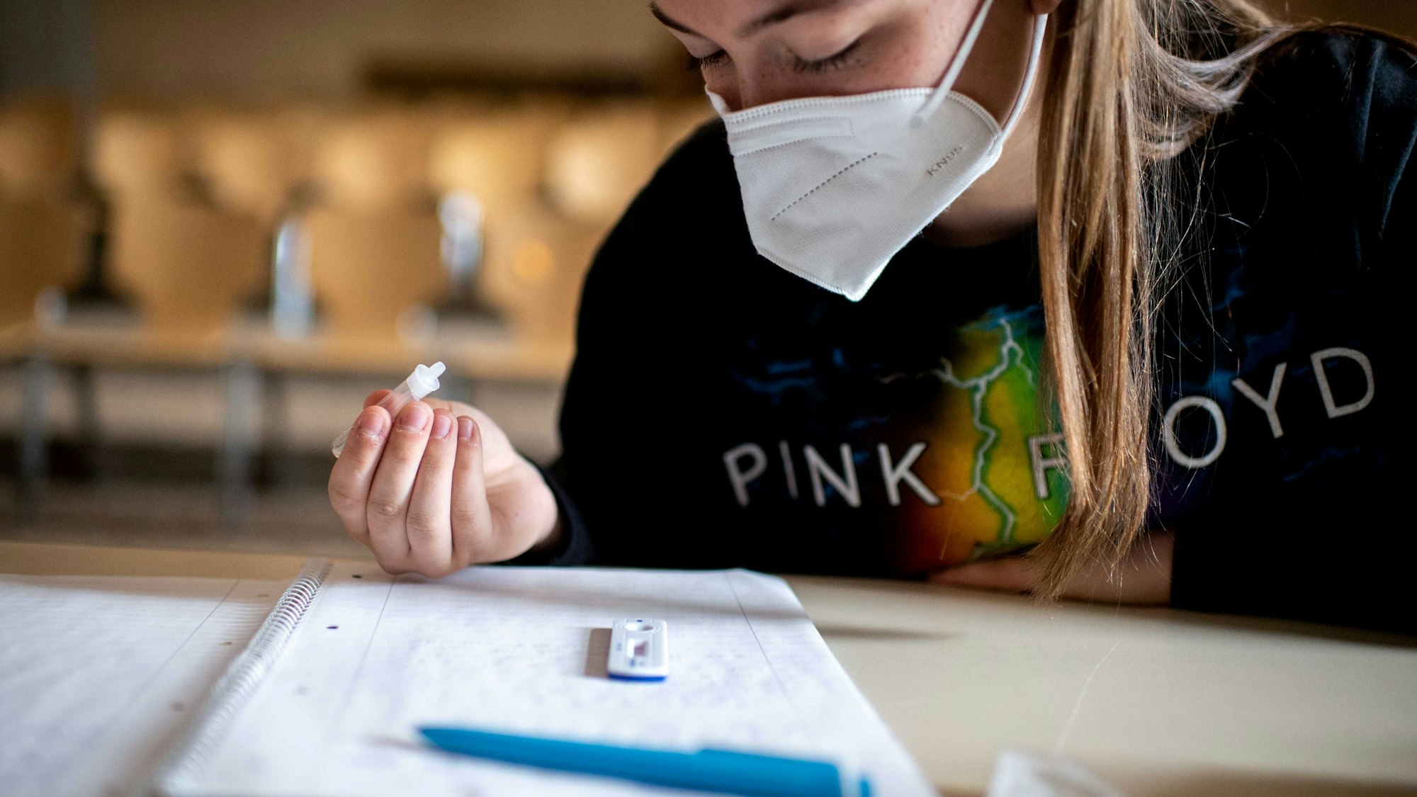 Eine Schülerin mit FFP2-Maske führt einen Coronatest durch.