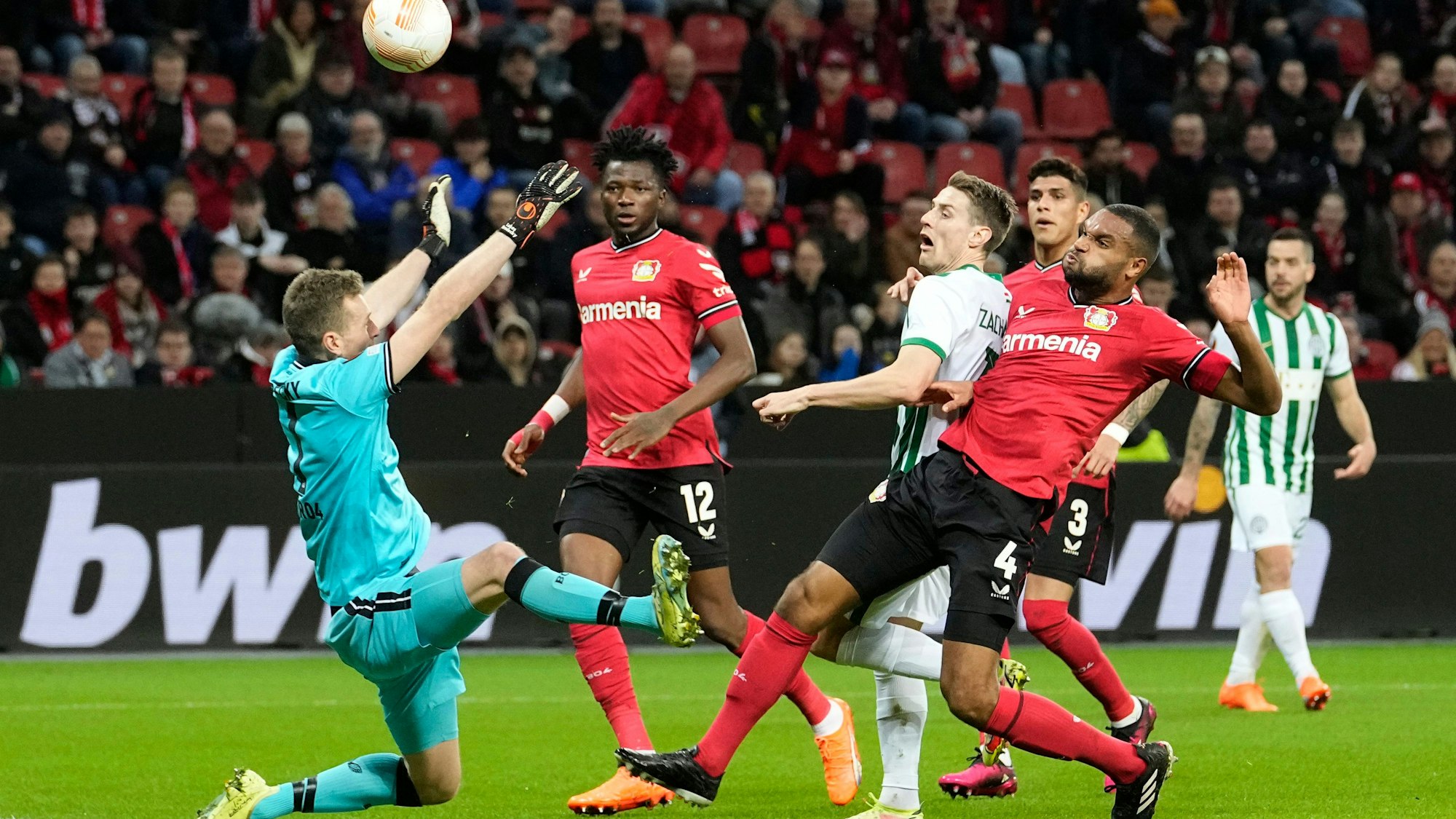 Ferencvaros' Kristoffer Zachariassen, centre right, fails to score past Leverkusen's goalkeeper Lukas Hradecky during the Europa League Round of 16 first leg soccer match between Bayer Leverkusen and Ferencvaros in Leverkusen, Germany, Thursday, March 9, 2023. (AP Photo/Martin Meissner)