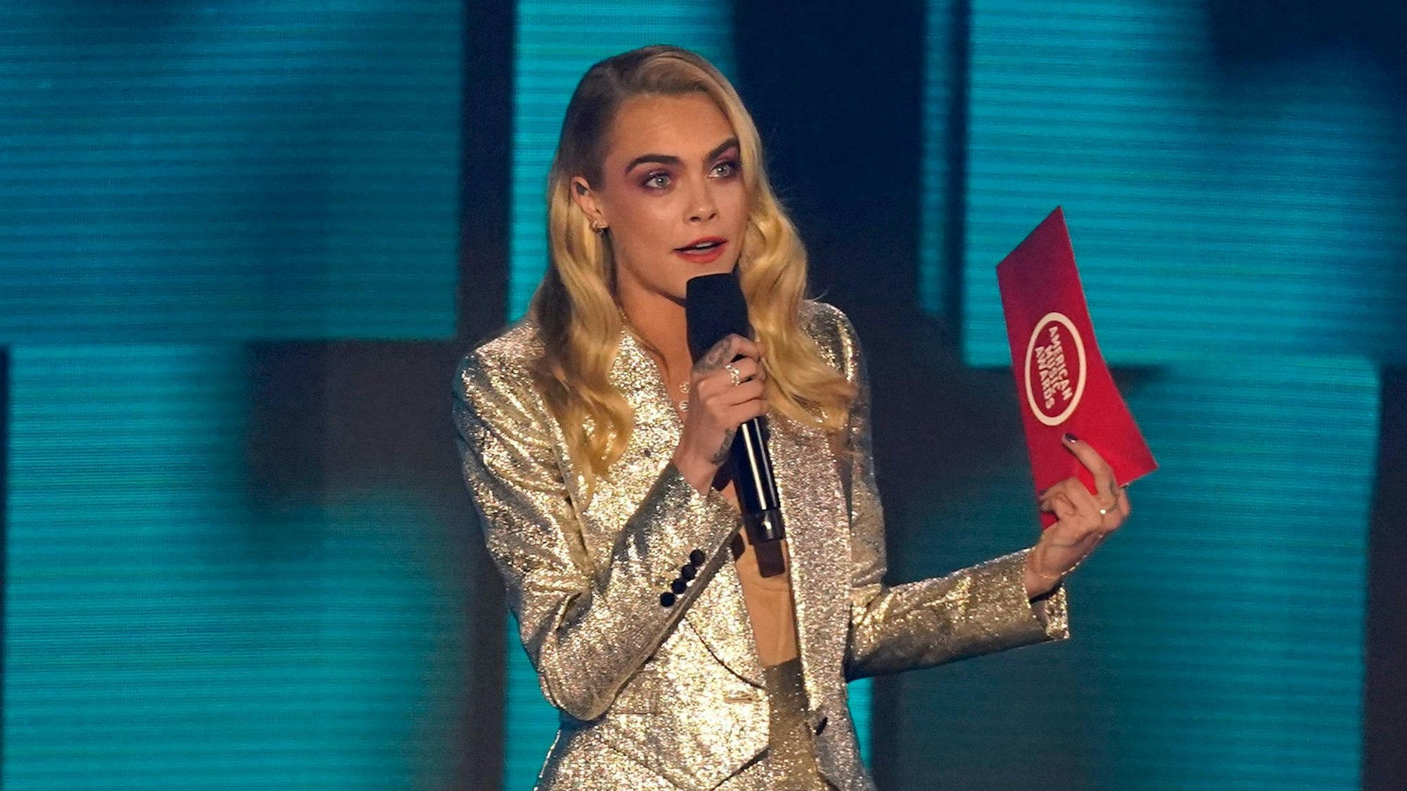 Model Cara Delevigne mit Mikro auf der Bühne.