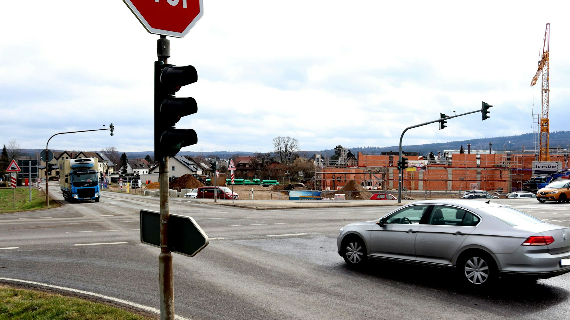 Ein Auto wartet an einer Kreuzung, dass es links abbiegen kann
