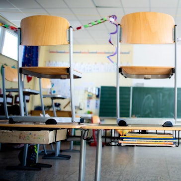 Stühle stehen nach Schulschluss auf den Tischen in einem Unterrichtsraum.