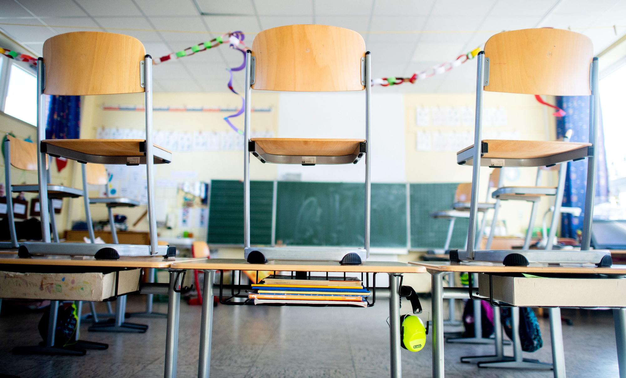 Stühle stehen nach Schulschluss auf den Tischen in einem Unterrichtsraum einer Grundschule.