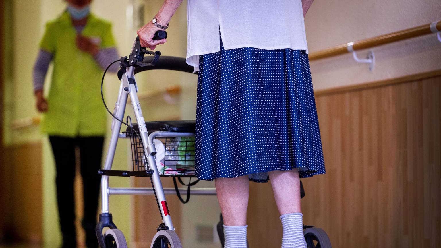 Eine Bewohnerin ist mit ihrem Rollator auf dem Flur eines Alten- und Pflegeheims unterwegs. (zu dpa: "Ministerium hat Corona-Anstieg in der Pflege «auf dem Schirm»") +++ dpa-Bildfunk +++