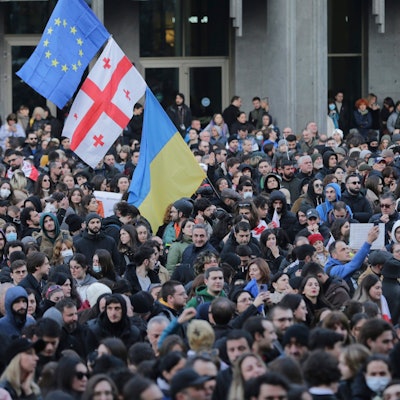 ARCHIV - 08.03.2023, Georgien, Tiflis: Demonstranten versammeln sich mit georgischen, ukrainischen und EU-Fahnen vor dem georgischen Parlamentsgebäude.