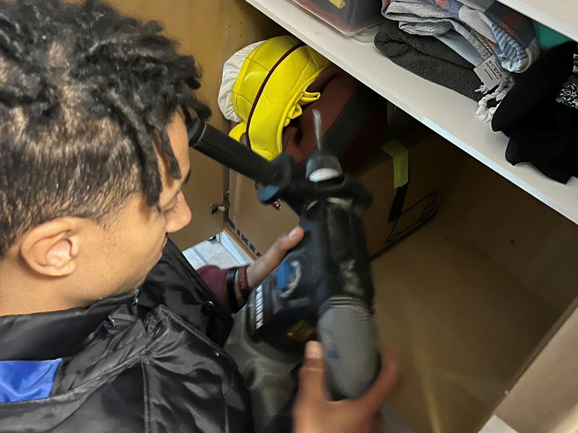 Ein Mann hält eine Bohrmaschine.