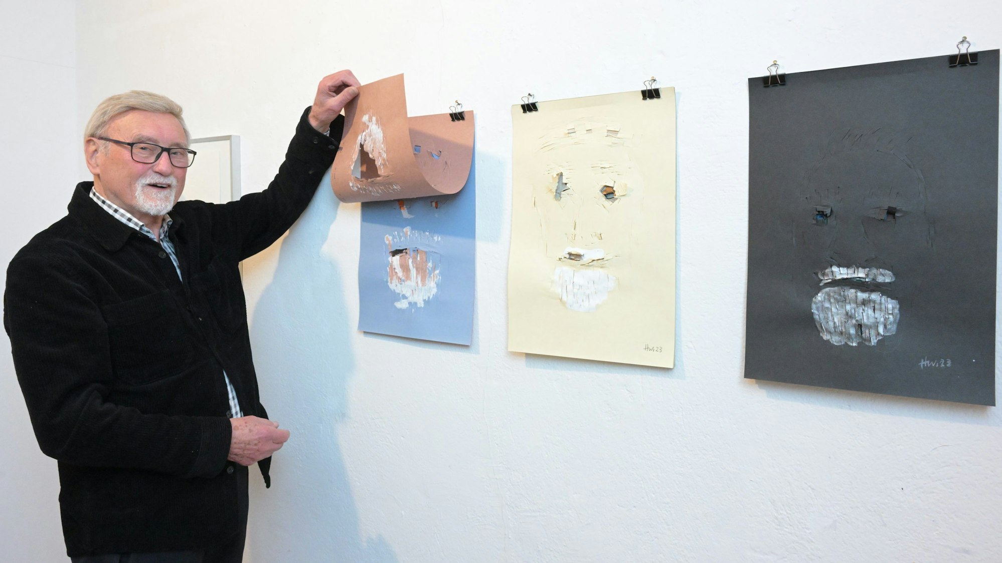 Wolfgang Heuwinkel steht vor seinen Selbstporträts.