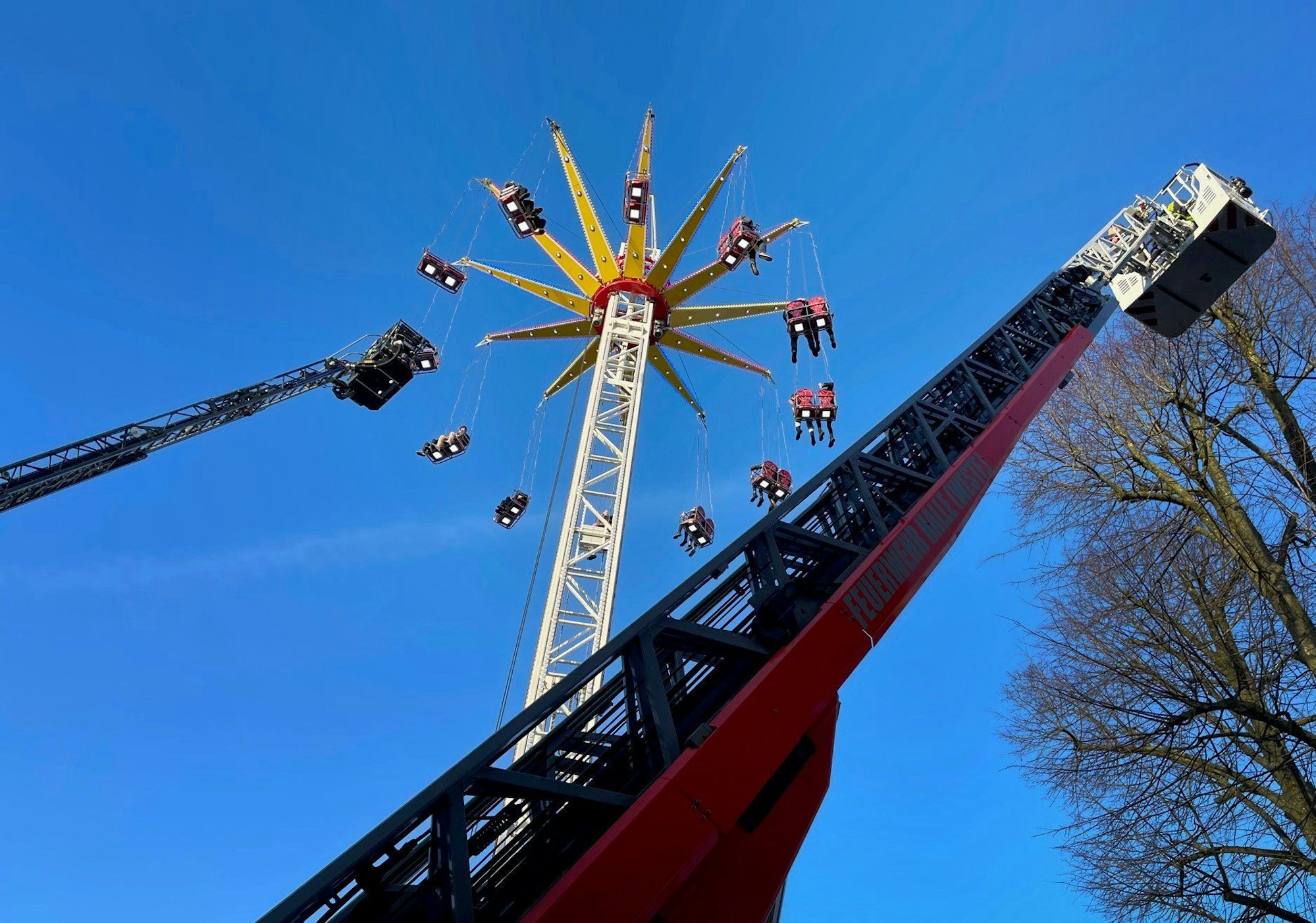 Menschen werden wegen eines Defekts in einem Kettenkarussell auf einer Kirmes in Halle (Westfalen) von der Feuerwehr mit Leiterwagen gerettet.