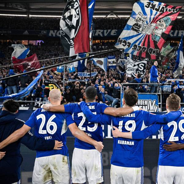 Schalkes Spieler jubeln nach ihrem Sieg gegen Dortmund mit den Fans.