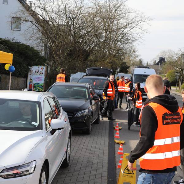Menschen in Warnwesten nehmen Spenden in Kartons entgegen, die mit Autos in einem Drive-in angeliefert werden.