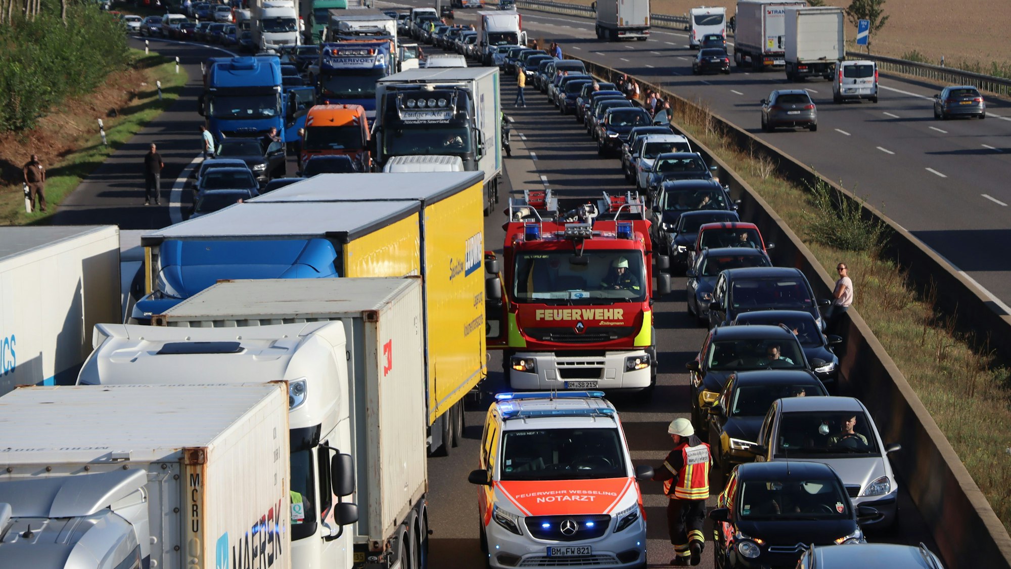 Feuerwehrfahrzeuge sind auf der vollen A1 unterwegs durch die Rettungsgasse, die die Autofahrer gebildet haben.