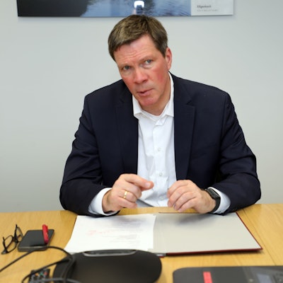 Stephan Santelmann, Landrat des Rheinisch-Bergischen Kreises, sitzt an einem Tisch.