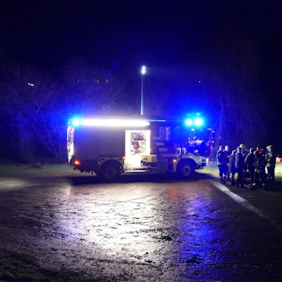 Am nächtlichen Siegufer stehen ein Feuerwehrauto und Feuerwehrleute, auch ein Schlauchboot ist am Ufer.