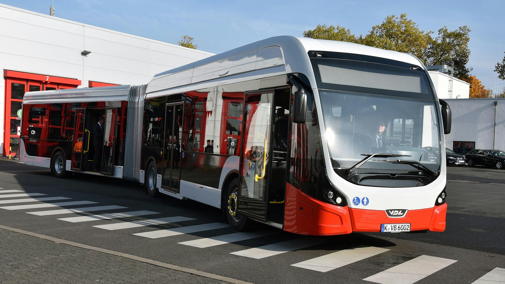 Ein Gelenkbus der KVB steht auf einem Parkplatz.