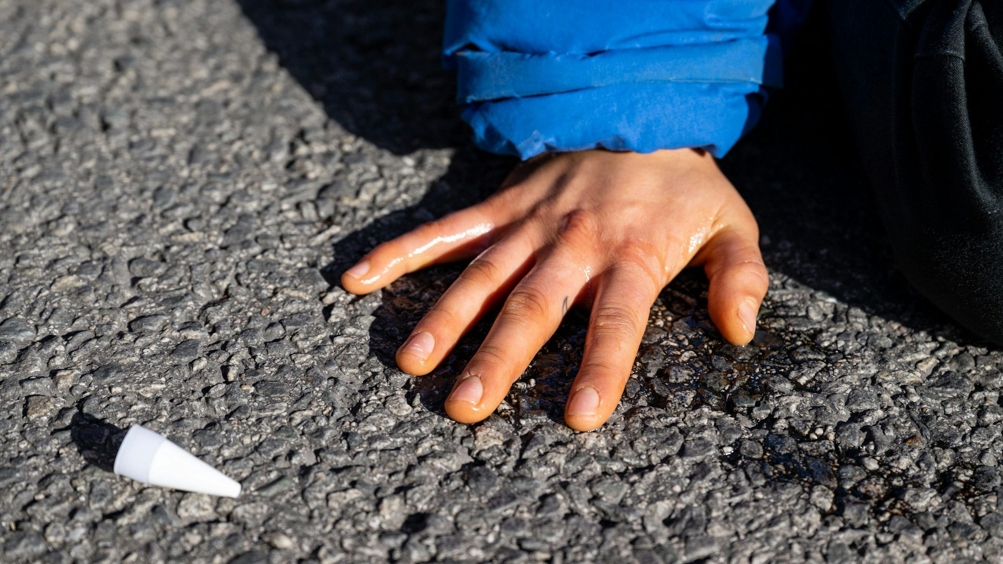 ARCHIV - 03.11.2022, Bayern, München: Klimaaktivisten haben sich am Karlsplatz in der Innenstadt auf die Fahrbahn geklebt und blockieren die Straße.