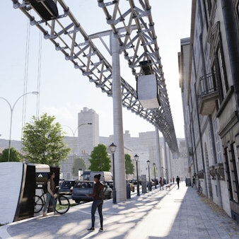 Die Gondel einer Schwebebahn ist am Boden, das Gerüst der Bahn läuft über dem Fußgängerweg her.