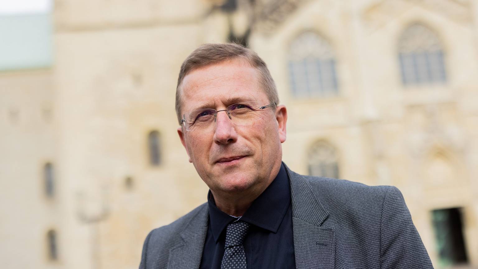 Thomas Schüller steht vor einer Kirche.