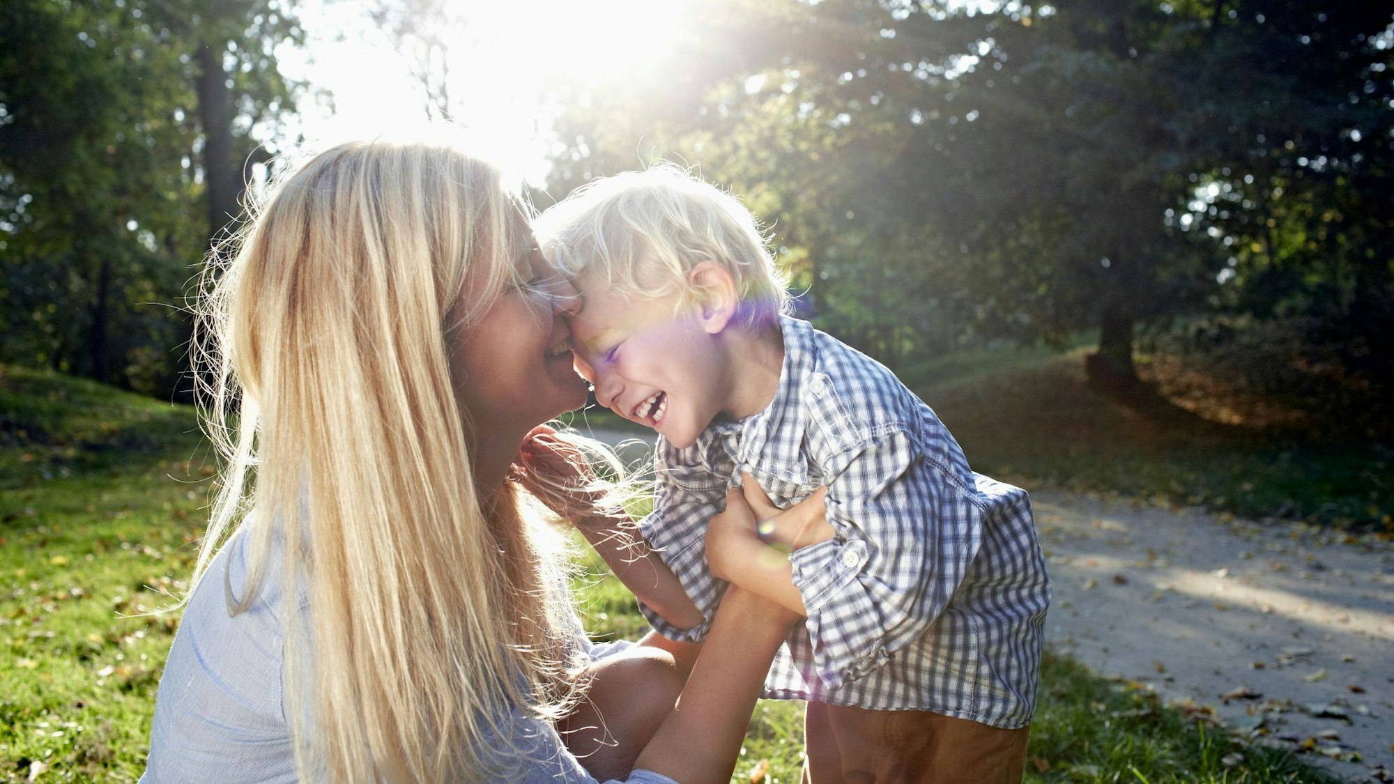 Eine Mutter tobt und kuschelt mit ihrem Sohn.
