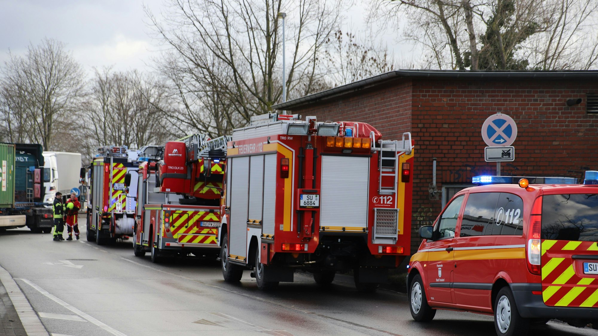 Einsatzfahrzeuge der Feuerwehr stehen aufgereiht an einer Straße.