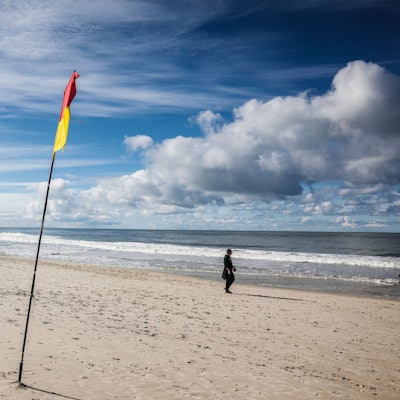 Spaziergänger gehen bei Sonnenschein am Brandenburger Strand spazieren.