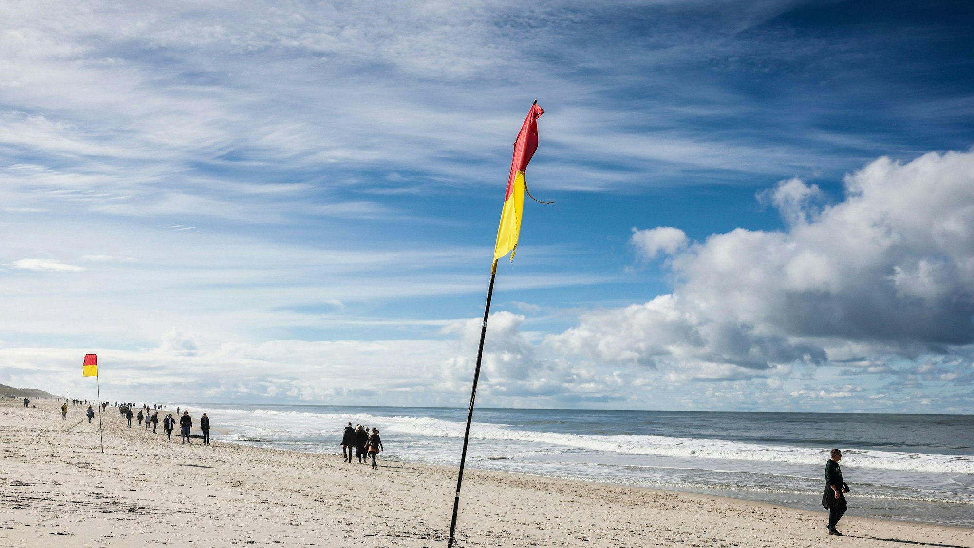 Spaziergänger gehen bei Sonnenschein am Brandenburger Strand spazieren.