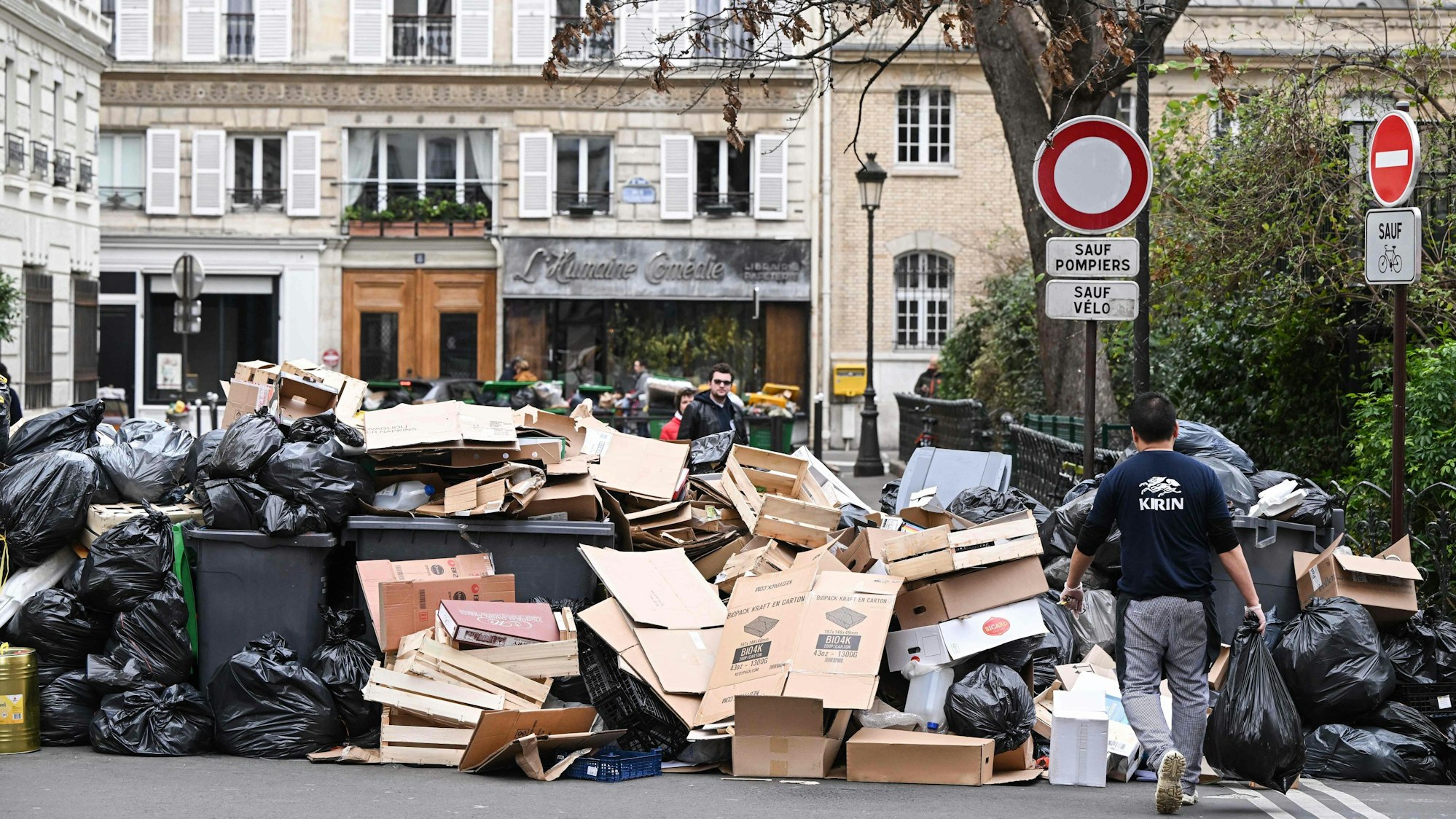 Müll stapelt sich auf und vor den Hausmüllcontainern in einer Pariser Straße.