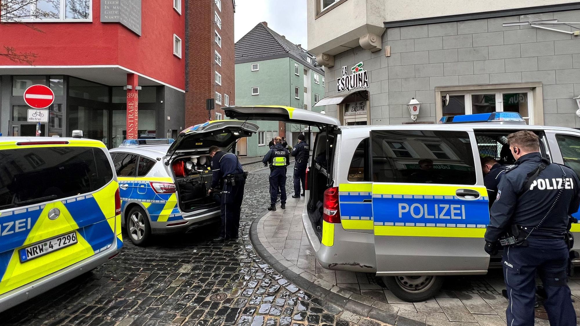 Einsatzwagen und Einsatzkräfte der Polizei stehen am Tatort.