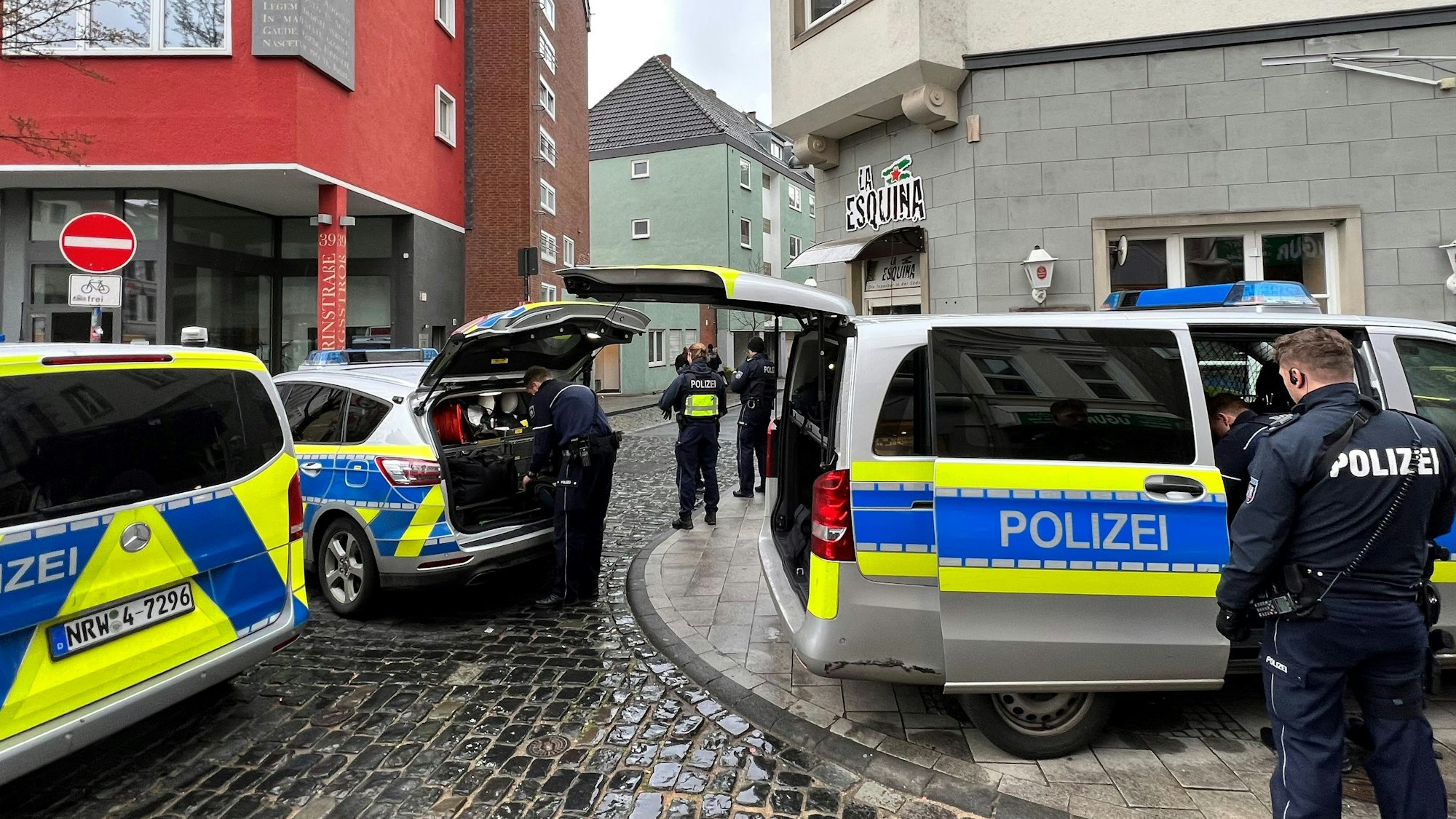 Einsatzwagen und Einsatzkräfte der Polizei stehen am Tatort.