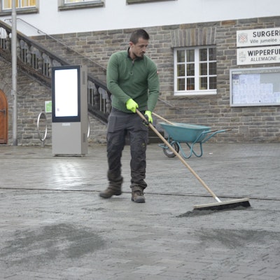 Ein Mitarbeiter der Firma G.W.D. verfugt die Grauwackesteine auf dem Marktplatz neu.