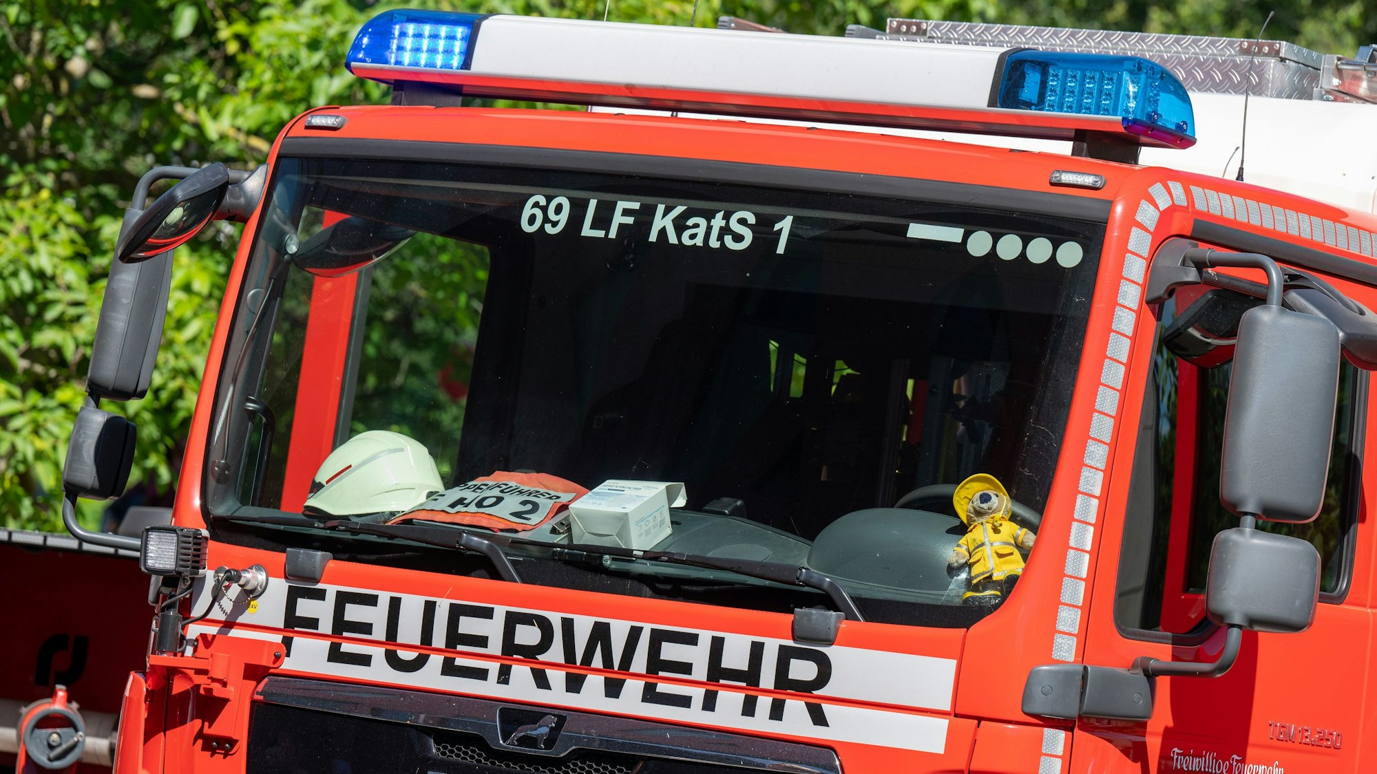 Ein Feuerwehrauto steht vor Bäumen. (Symbolbild)