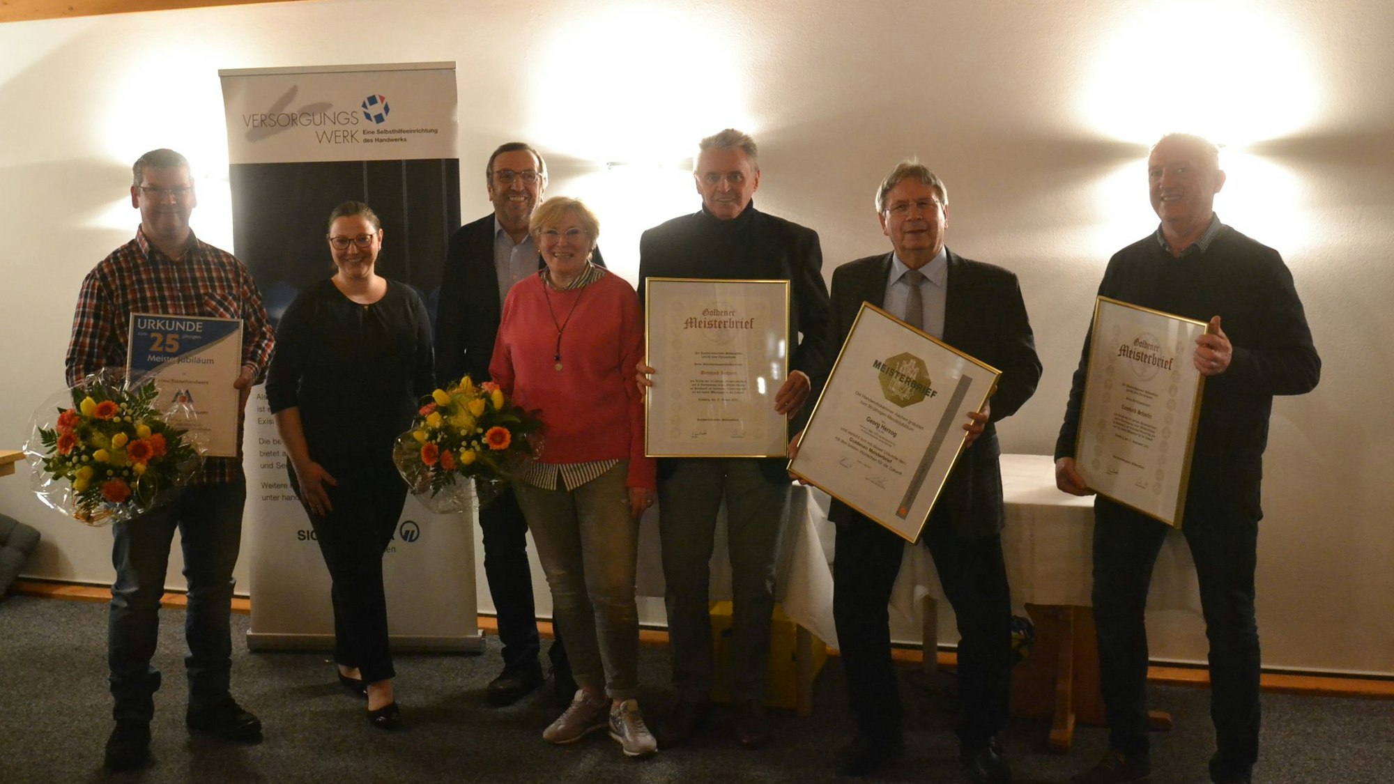 Leonard Schäfer, Georg Herzog und Bernhard Kuhnert halten ihre Meisterdiplome in der Hand. Neben ihnen stehen Vanessa Becker – Geschäftsführerin KHS, Wilfried Schneider – Obermeister und Gisela Simons – Lebensgefährtin von Goldmeister Bernhard Kuhnert.