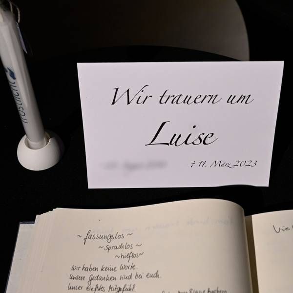 Man sieht die Trauerkarte samt Kondolenzbuch und einen Stift.