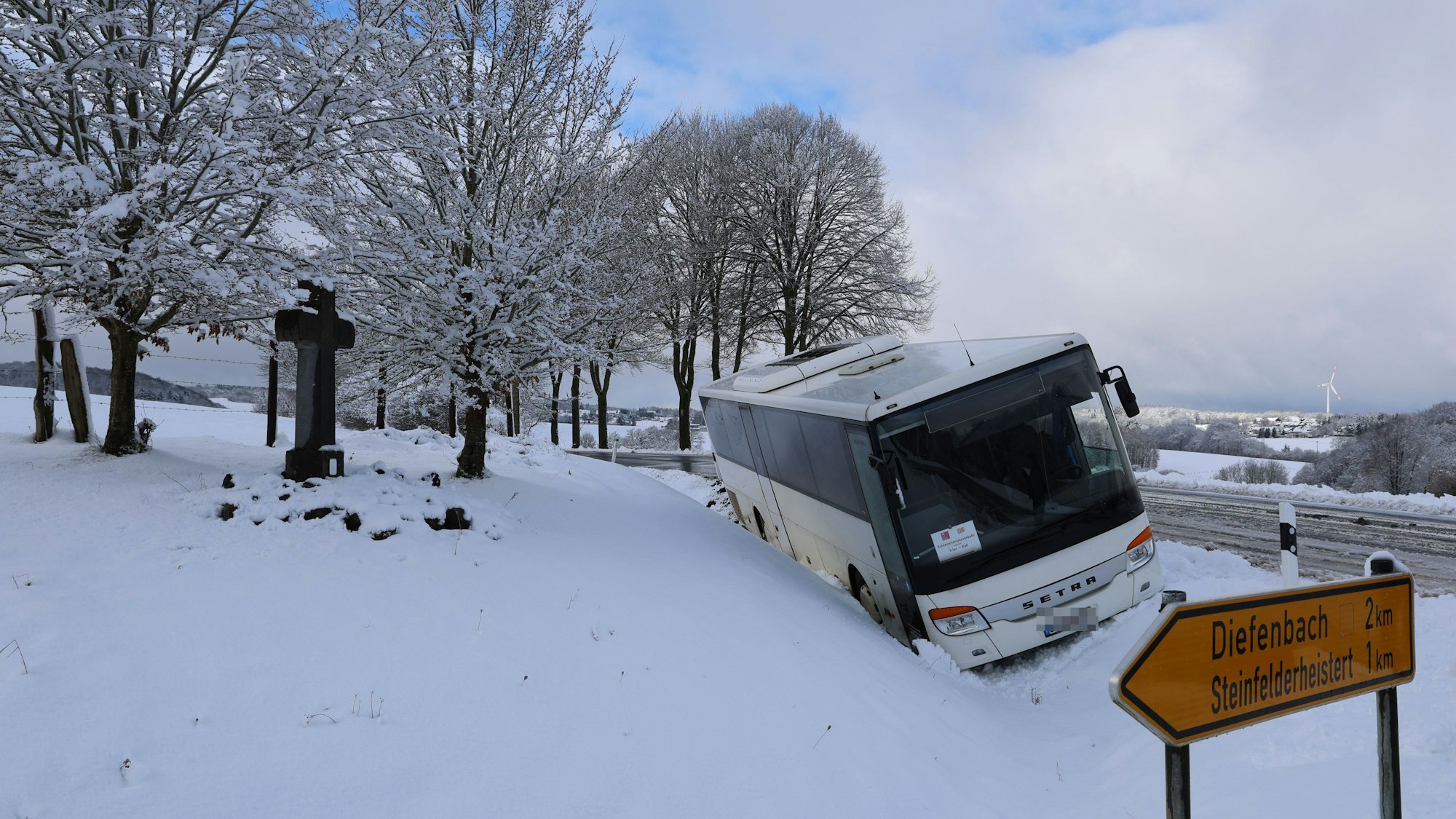 Ein Bus liegt in einem Graben und muss mit einem Kran geborgen werden.