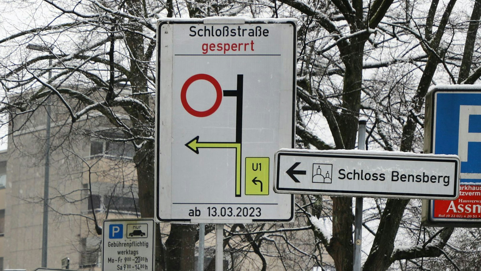 Auf einer großen Schildertafel steht „Schloßstraße gesperrt“, darunter ist eine Umleitung ausgewiesen. Ein weiteres Schild weist den Weg zum Schloss Bensberg.