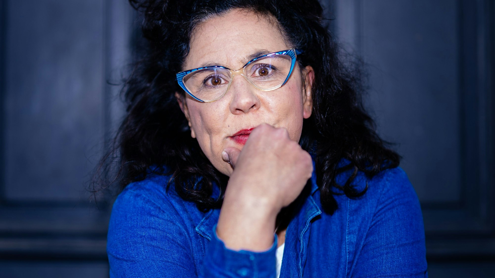 Ramona Schukraft alias Sybille Bullatschek trägt einen blauen Blazer und eine blaue Brille.