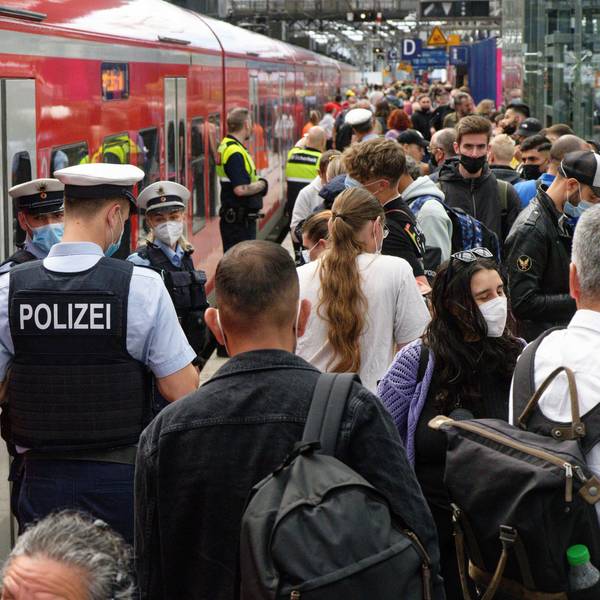 Polizei und Mitarbeiter der Deutschen Bahn weisen Reisenden auf einem überfülltem Bahnsteig im Hauptbahnhof den Weg.