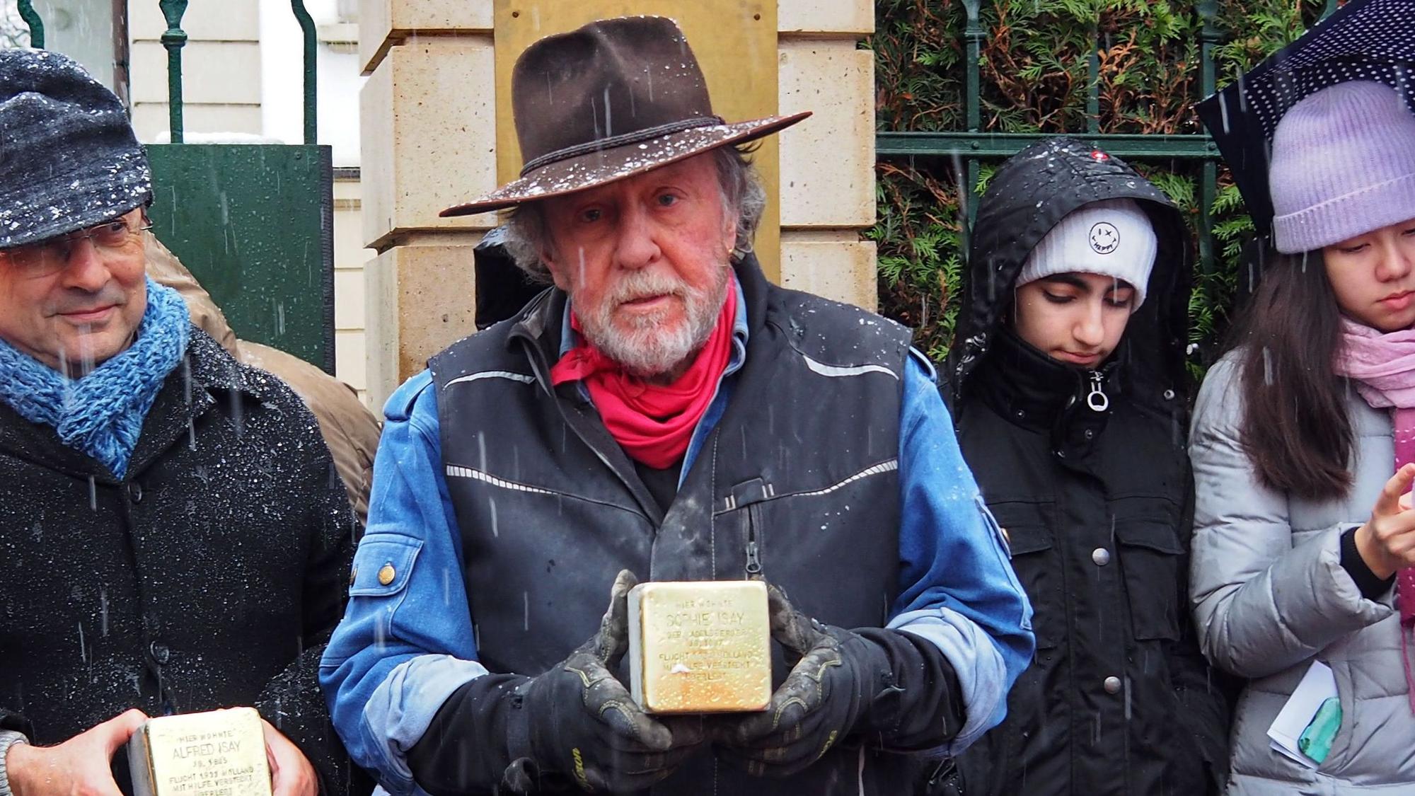 Künstler Gunter Demnig mit einem Stolperstein in der Hand