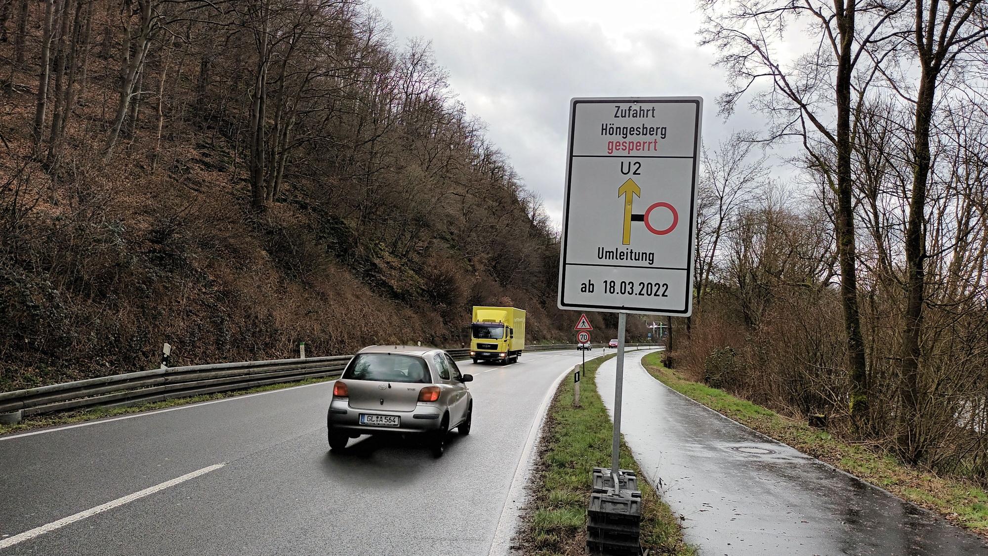 Blick auf die Verbindungsstrecke. Zwei Autos fahren auf der Straße. Ein Schild zeigt, dass die Strecke Höngesberg gesperrt ist.