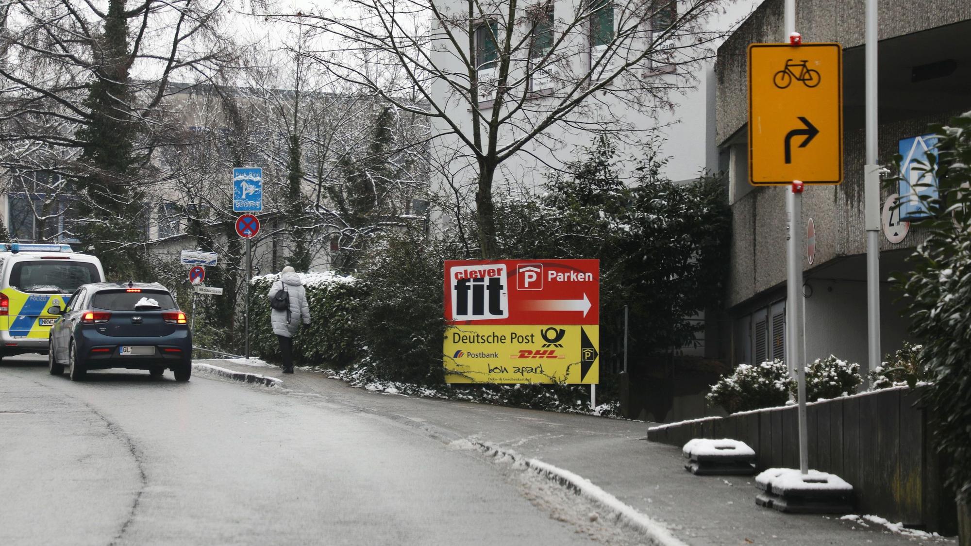 Ein Umleitungsschild für Fahrräder steht auf dem Gehweg neben einer Straße in einem Hartgummi-Fuß. Dahinter steht ein weiterer Hartgummi-Schilderfuß, allerdings ohne Schild.