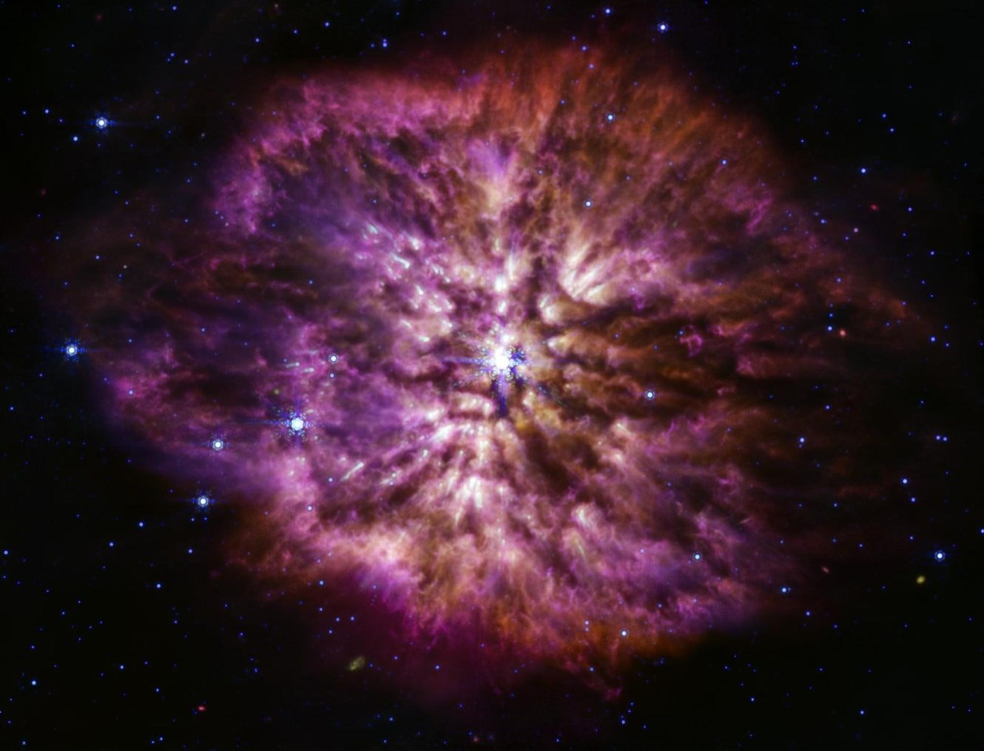 Der leuchtende, heiße Stern Wolf-Rayet 124 (WR 124) ist im Zentrum des zusammengesetzten Bildes des James Webb Weltraumteleskops zu sehen, das Licht der Nahinfrarotkamera und des Mittelinfrarot-Instruments von Webb im nahen und mittleren Infrarot kombiniert.