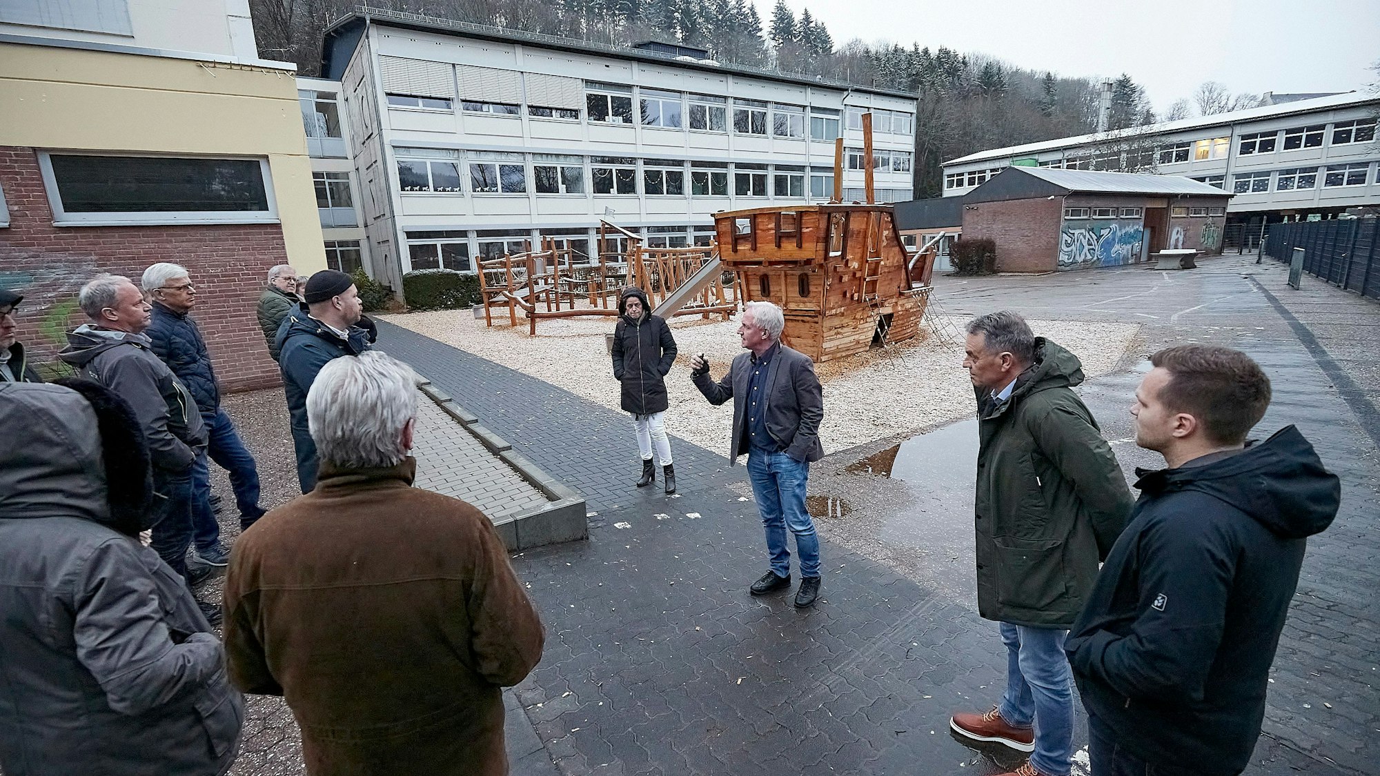 Schulleiter Wolfgang Schmitz und die Mitglieder des Ausschusses stehen auf dem Schulhof der Astrid-Lindgren-Förderschule.