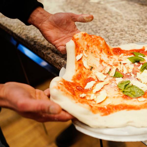 Eine noch ungebackene Pizza auf einem Ofenschieber