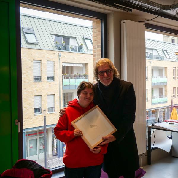 Das Foto zeigt Nicole Fellmann und Toni Schumacher. Sie schenkte der Torwart-Legende ein von ihr geschriebenes Gedicht in einem Bilderrahmen.