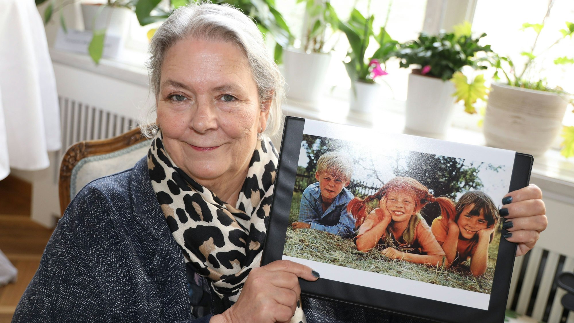 Maria Persson, ehemals Annika-Darstellerin in den Pippi-Langstrumpf-Filmen, hält ein Bild hoch.