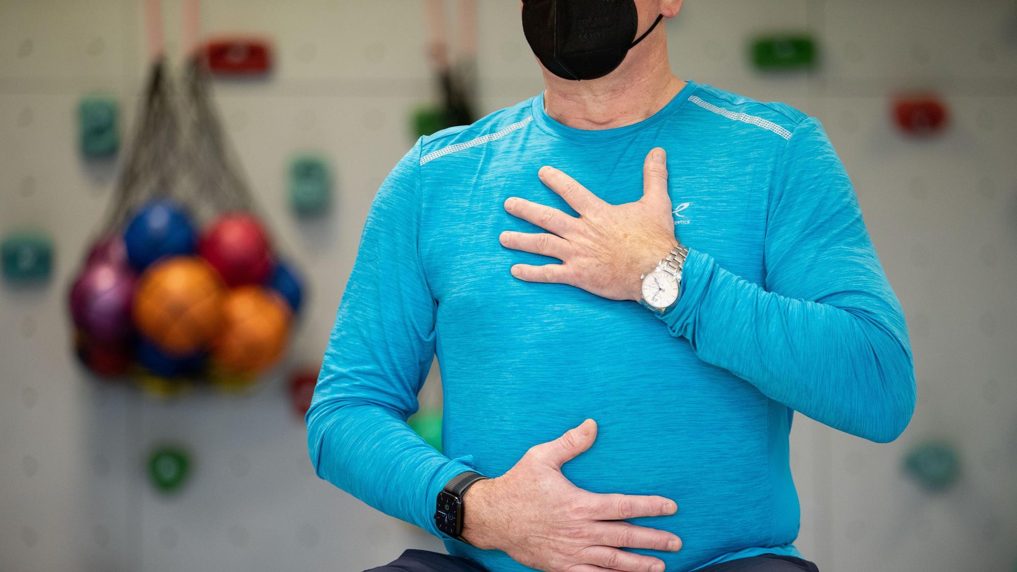 Ein long-covid-Patient macht ein Atemtraining in einem Gymnastikraum.